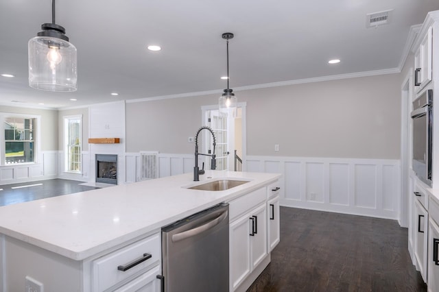 kitchen featuring visible vents, dark wood finished floors, a fireplace with flush hearth, stainless steel appliances, and a sink