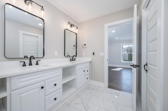 bathroom featuring marble finish floor, a sink, baseboards, and double vanity