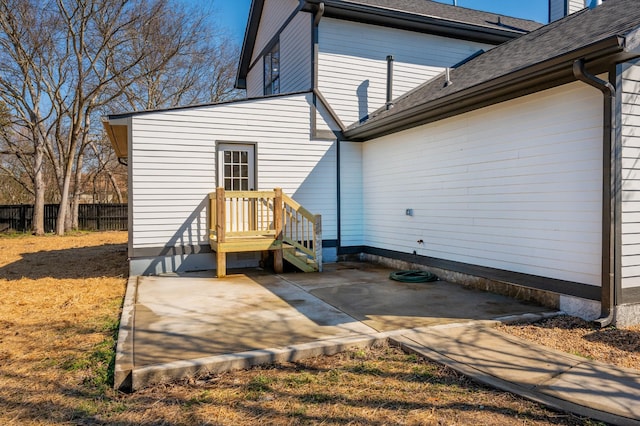 exterior space featuring a shingled roof, a patio area, and fence