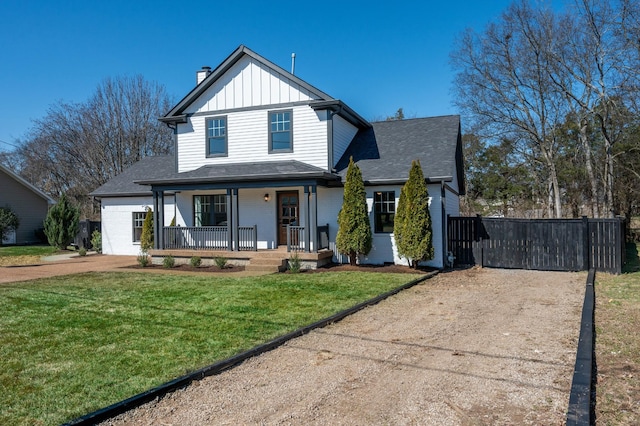 view of front of home with dirt driveway, a front yard, a porch, board and batten siding, and brick siding