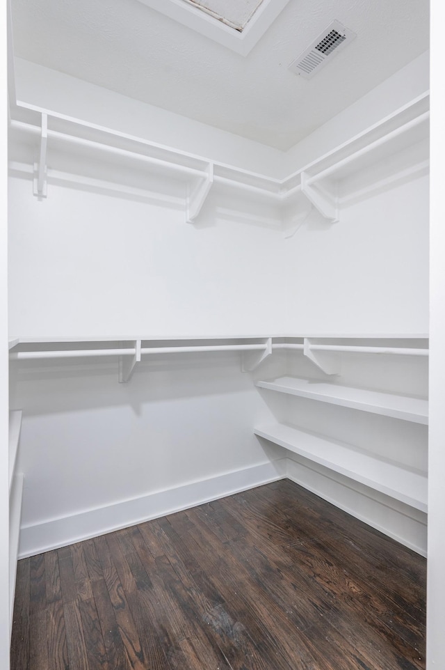 spacious closet with dark wood-style flooring and visible vents