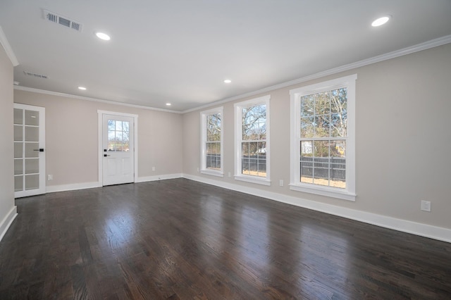 empty room featuring dark wood-style flooring, visible vents, crown molding, and baseboards