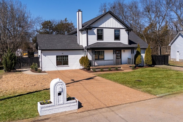 view of front of property with driveway, a chimney, fence, a porch, and board and batten siding