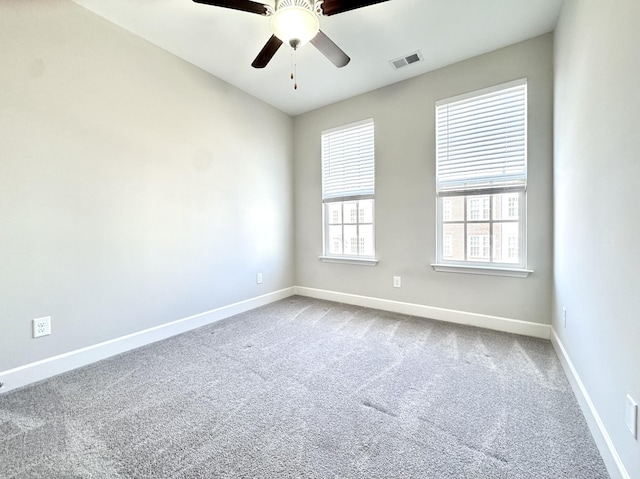 unfurnished room featuring a ceiling fan, carpet flooring, visible vents, and baseboards