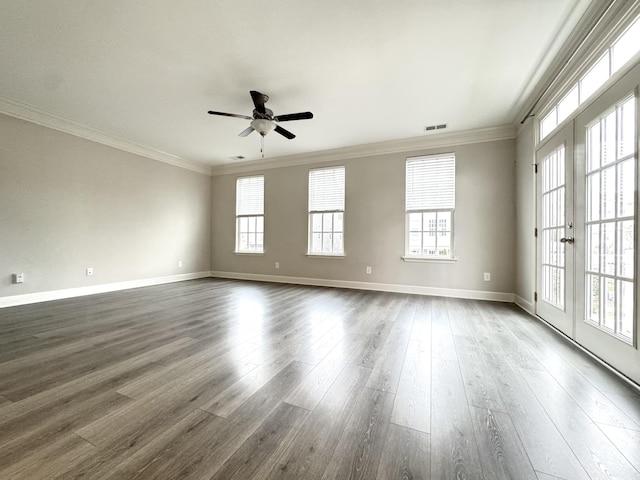 spare room with ornamental molding, plenty of natural light, and dark wood finished floors