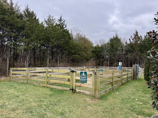 view of yard featuring fence and a wooded view