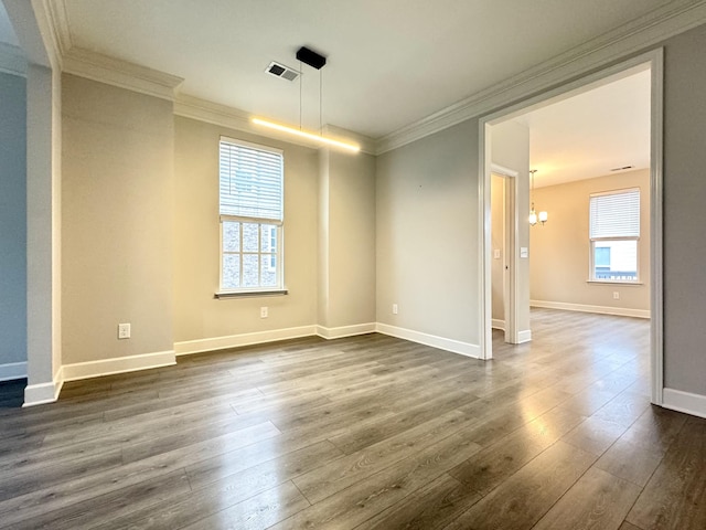 empty room featuring ornamental molding, a healthy amount of sunlight, and dark wood finished floors