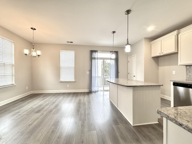 kitchen featuring dark wood-style floors, a notable chandelier, light stone counters, and dishwasher