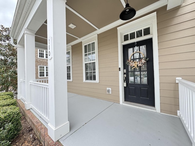 property entrance featuring ceiling fan and a porch