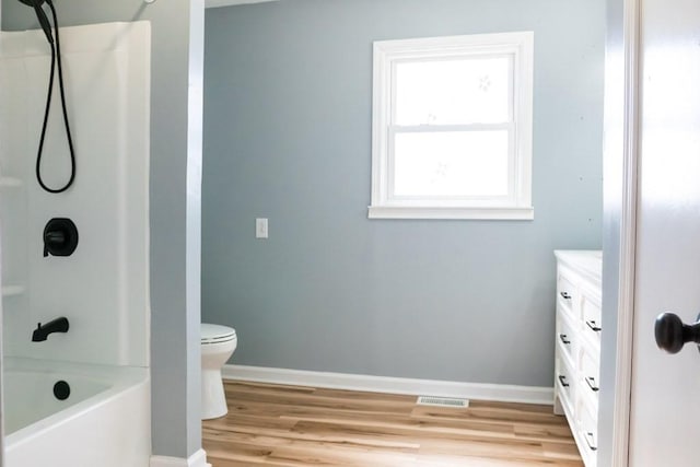 full bathroom featuring shower / bathtub combination, baseboards, wood finished floors, and vanity