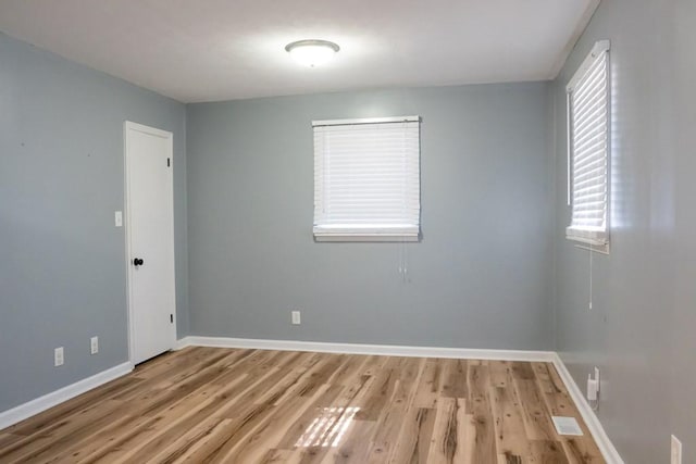 spare room featuring wood finished floors and baseboards