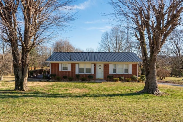 single story home featuring a front yard, metal roof, and brick siding