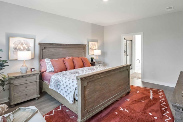 bedroom with wood finished floors, visible vents, and baseboards