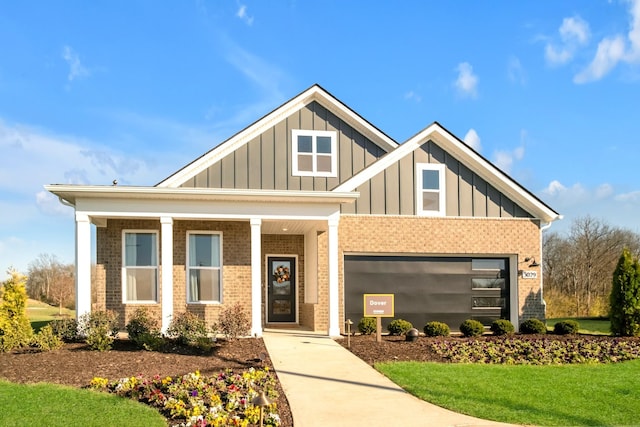 craftsman-style home featuring a garage, a front lawn, board and batten siding, and brick siding