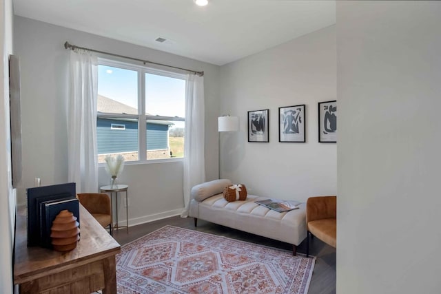 living area featuring wood finished floors, visible vents, and baseboards