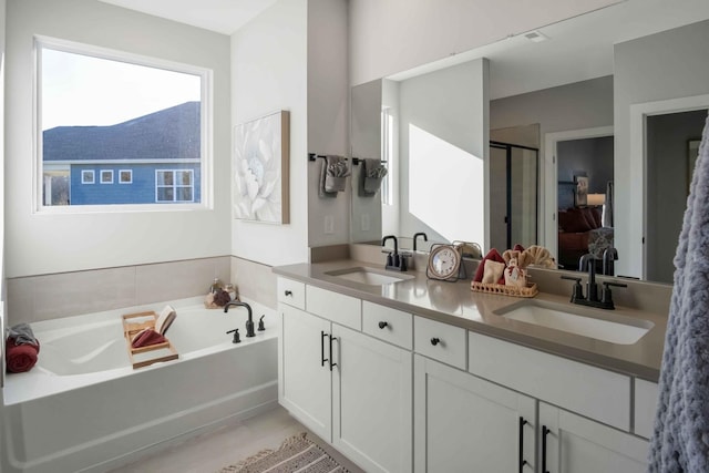 full bathroom with double vanity, a sink, a shower stall, and a bath