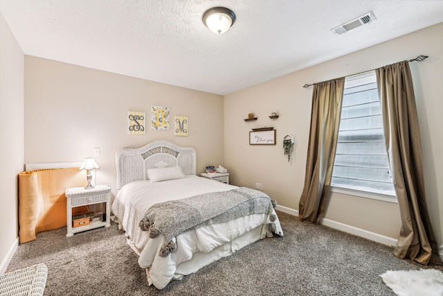 carpeted bedroom with baseboards, visible vents, and a textured ceiling