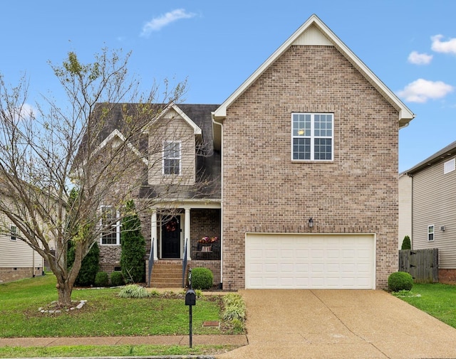 traditional-style house featuring brick siding, covered porch, a front yard, a garage, and driveway