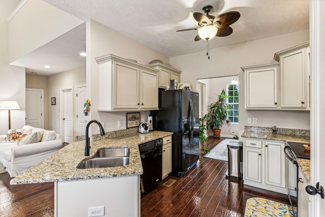 kitchen with dark wood-type flooring, a sink, light stone countertops, a peninsula, and black appliances