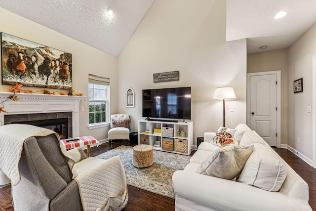 living area with recessed lighting, a tiled fireplace, vaulted ceiling, wood finished floors, and baseboards