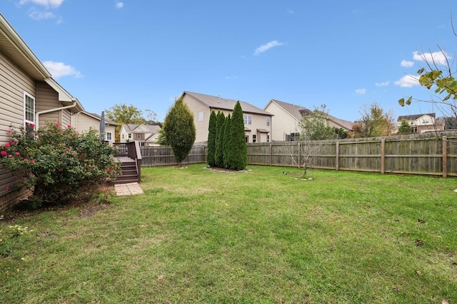 view of yard featuring a residential view, a fenced backyard, and a wooden deck