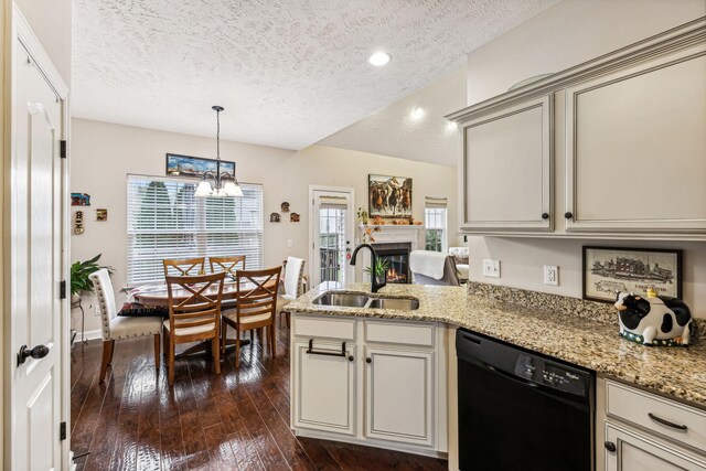 kitchen with a warm lit fireplace, a peninsula, a sink, black dishwasher, and dark wood-style floors