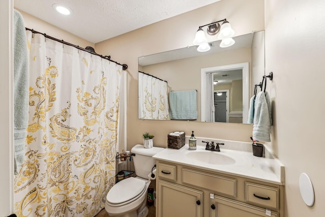 full bathroom featuring curtained shower, vanity, toilet, and a textured ceiling