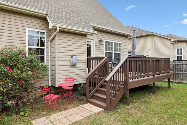 rear view of property with a shingled roof, fence, and a wooden deck