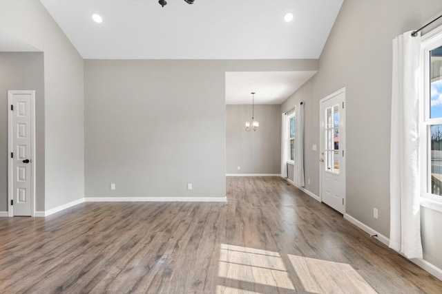 entryway featuring baseboards, a chandelier, wood finished floors, and recessed lighting