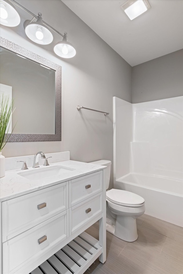 bathroom with shower / washtub combination, vanity, and toilet