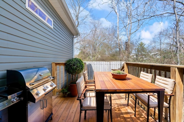 wooden terrace featuring outdoor dining area and a grill