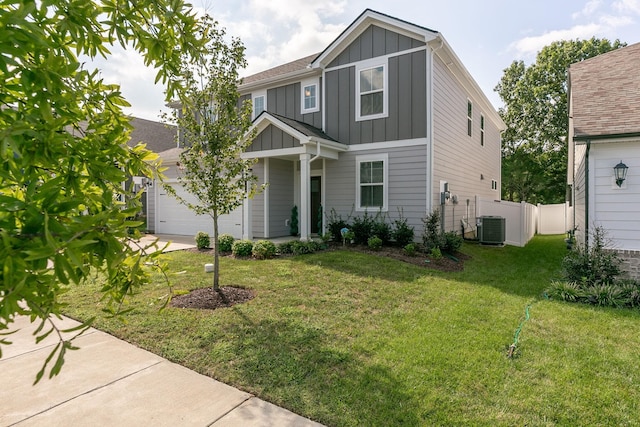 view of front facade with central AC unit, an attached garage, fence, board and batten siding, and a front yard