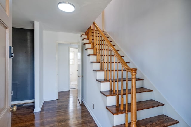 stairway with baseboards and wood finished floors