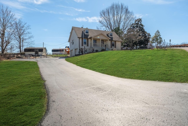 view of front of home featuring aphalt driveway and a front lawn