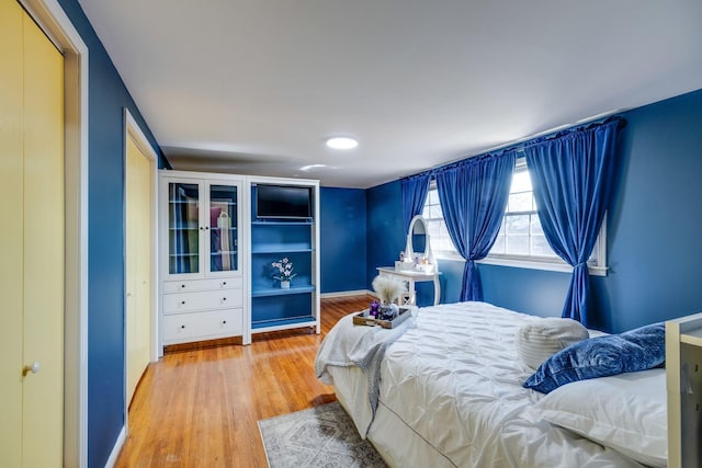 bedroom with light wood-type flooring and baseboards