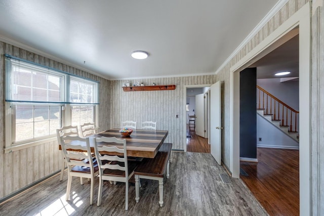 dining area featuring ornamental molding, visible vents, stairs, and wood finished floors