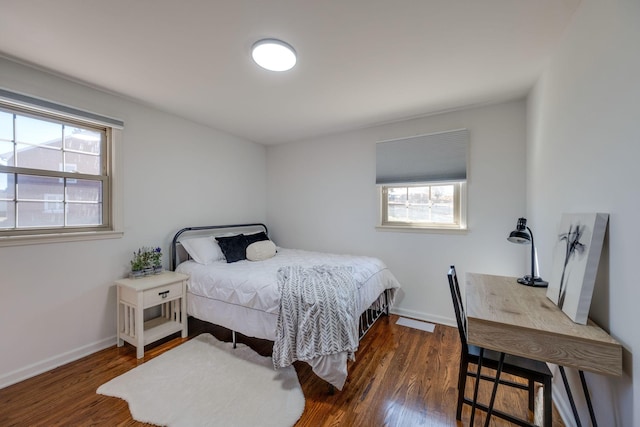 bedroom featuring multiple windows, wood finished floors, and baseboards