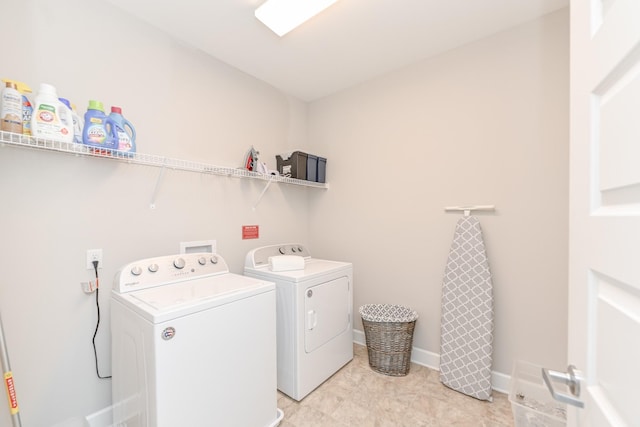 washroom featuring washer and dryer, laundry area, and baseboards