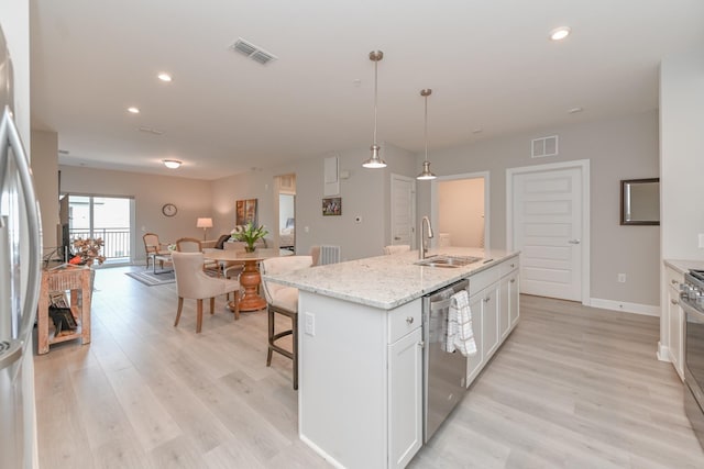 kitchen featuring white cabinetry, visible vents, appliances with stainless steel finishes, and a sink