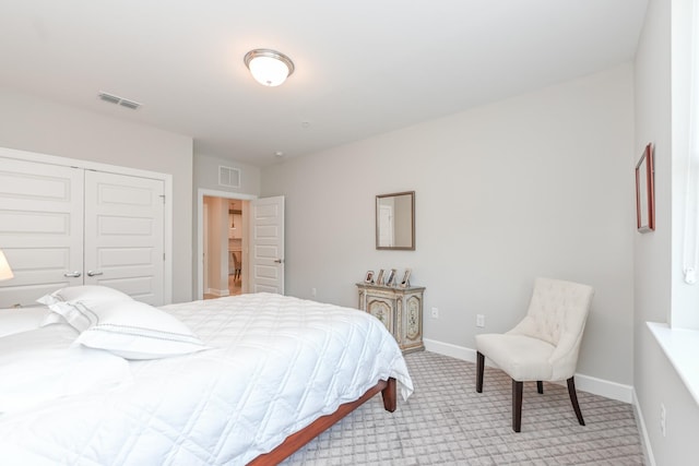 carpeted bedroom featuring visible vents, baseboards, and a closet