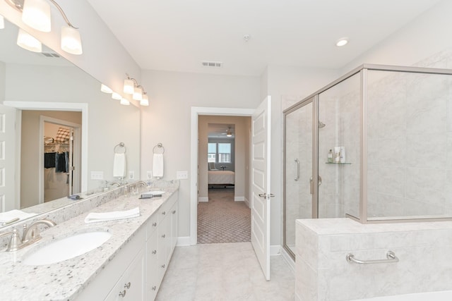 full bathroom with visible vents, a stall shower, a sink, double vanity, and a spacious closet