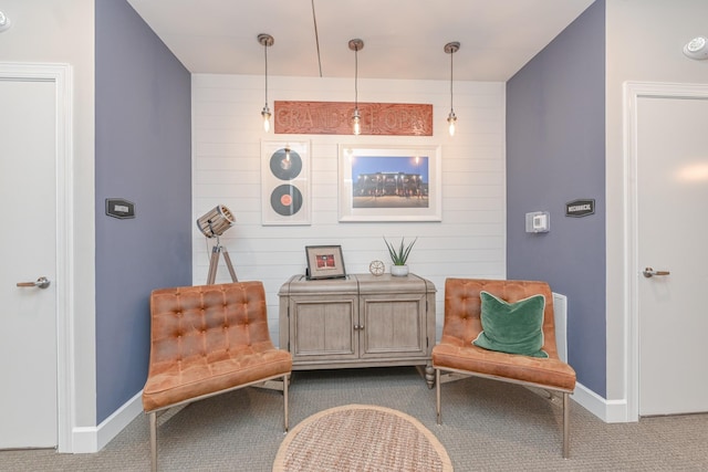 living area featuring baseboards and dark carpet