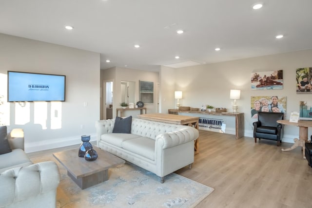 living area featuring light wood-type flooring, baseboards, and recessed lighting