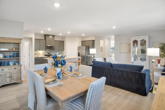 dining space with light wood finished floors and recessed lighting