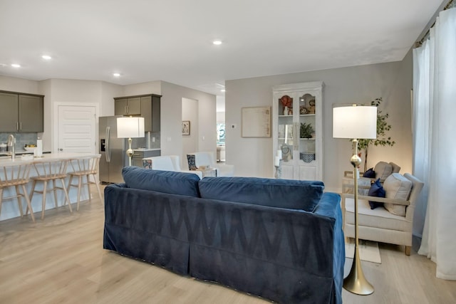 living area with light wood-style flooring and recessed lighting