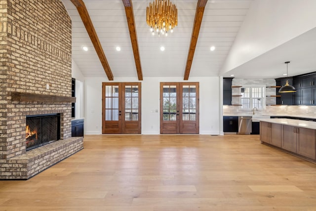 998 Iron Hill Rd, Burns, TN 37029 - unfurnished living room featuring a brick fireplace, light wood-style flooring, high vaulted ceiling, and french doors