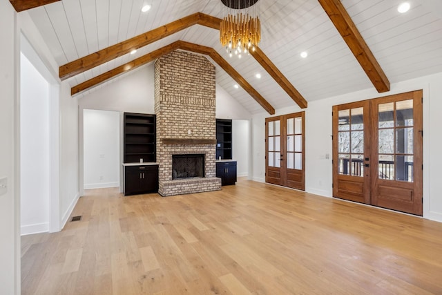 998 Iron Hill Rd, Burns, TN 37029 - unfurnished living room featuring beam ceiling, a brick fireplace, french doors, and light wood finished floors