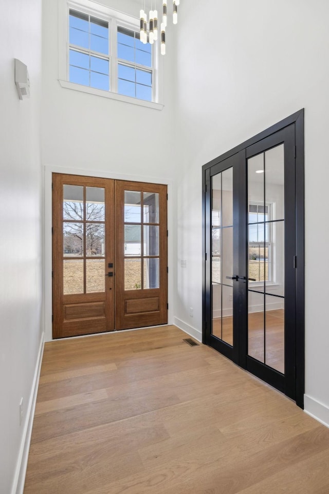 998 Iron Hill Rd, Burns, TN 37029 - doorway with french doors, plenty of natural light, wood finished floors, and an inviting chandelier