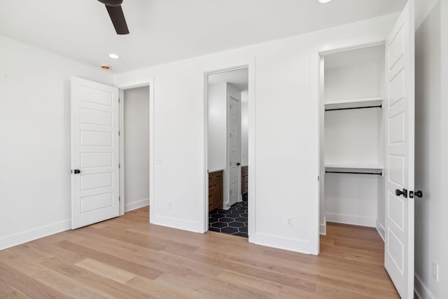 998 Iron Hill Rd, Burns, TN 37029 - unfurnished bedroom featuring a walk in closet, a closet, light wood-style flooring, ensuite bath, and baseboards