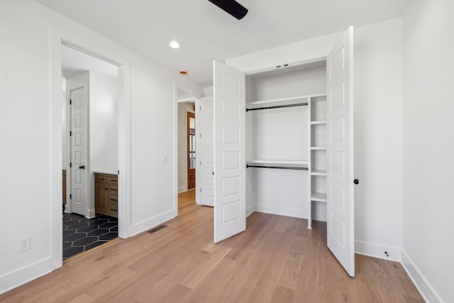 998 Iron Hill Rd, Burns, TN 37029 - unfurnished bedroom featuring baseboards, a closet, visible vents, and light wood-style floors